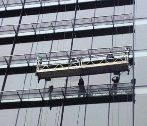 Technicians Caulking and Sealing Windows with a mobile stage